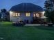 Backyard at twilight featuring a patio, firepit, and dining area illuminated by outdoor lighting at 2317 Emerald Woods Dr, Wake Forest, NC 27587