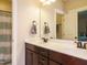 Bright bathroom with double vanity, framed mirror, dark wood cabinets, and shower-tub combo at 2317 Emerald Woods Dr, Wake Forest, NC 27587