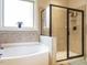 Bright bathroom featuring a soaking tub, a glass-enclosed shower, and a large window at 2317 Emerald Woods Dr, Wake Forest, NC 27587
