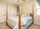 Spacious bedroom with four-poster bed, neutral carpet, and double closets with white doors at 2317 Emerald Woods Dr, Wake Forest, NC 27587