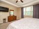 Comfortable bedroom with dresser, large windows providing natural light, and a ceiling fan at 2317 Emerald Woods Dr, Wake Forest, NC 27587