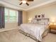 Cozy bedroom featuring a tray ceiling, plush bedding, and soft natural light from the window at 2317 Emerald Woods Dr, Wake Forest, NC 27587