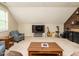 This is an upstairs bonus room with a large TV, several chairs and a built in cabinet at 2317 Emerald Woods Dr, Wake Forest, NC 27587