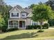 Charming two-story home with a stone-accented porch and well-manicured lawn and mature landscaping at 2317 Emerald Woods Dr, Wake Forest, NC 27587