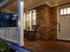 Inviting front porch featuring stone accents, rocking chairs, and a wooden deck at dusk at 2317 Emerald Woods Dr, Wake Forest, NC 27587