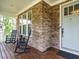 Inviting front porch featuring stone accents, rocking chairs, and a wooden deck at 2317 Emerald Woods Dr, Wake Forest, NC 27587