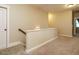 This is an upstairs hallway with neutral paint and carpet and a white wooden banister at 2317 Emerald Woods Dr, Wake Forest, NC 27587