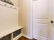 This is a mudroom with white bench seating and storage below with an adjacent white door at 2317 Emerald Woods Dr, Wake Forest, NC 27587