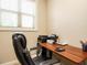 This is an office with a wood desk, black office chair and a printer next to a window at 2317 Emerald Woods Dr, Wake Forest, NC 27587