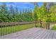 Backyard deck and wood railing with view of large landscaped backyard at 2418 Mont Haven Dr, Durham, NC 27712