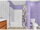 Well-lit bathroom features a shower-tub combo with floral shower curtain and a matching purple accent wall at 2418 Mont Haven Dr, Durham, NC 27712