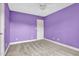 Carpeted bedroom with purple walls and a ceiling fan, presenting a calm and inviting space at 2418 Mont Haven Dr, Durham, NC 27712