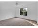 Bright, carpeted bedroom featuring a ceiling fan and a large window with a view of trees at 2418 Mont Haven Dr, Durham, NC 27712