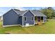 Exterior view of a blue two-story house, showcasing the side and back with a small porch at 25 Leisure Ln # 2, Louisburg, NC 27549