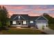 Charming home featuring a covered porch and an attached two-car garage, with a beautiful sunset at 25 Leisure Ln # 2, Louisburg, NC 27549