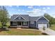 Charming home featuring a covered porch and an attached two-car garage, with landscaped yard at 25 Leisure Ln # 2, Louisburg, NC 27549