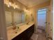 Bathroom featuring double sinks, a large mirror with lights, and a shower at 2709 Sardinia Ln, Apex, NC 27502