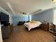 A blue bedroom with a bed, tv, entertainment center, and hardwood style flooring at 2709 Sardinia Ln, Apex, NC 27502