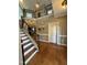 Bright foyer with hardwood floors, staircase, and an upper level landing with decorative wrought iron railing at 2709 Sardinia Ln, Apex, NC 27502