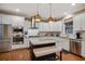 Modern kitchen boasts white cabinets, stainless steel appliances, granite counters and a center island with seating at 2709 Sardinia Ln, Apex, NC 27502