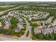 Aerial view of a neighborhood full of houses nestled among lush trees, with a highway visible in the distance at 2832 Cameron Pond Dr, Cary, NC 27519