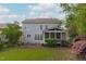 Back exterior showcasing a house with a screened porch and a well-manicured backyard at 2832 Cameron Pond Dr, Cary, NC 27519
