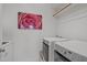 Well-lit laundry room with modern machines, storage shelves, and a decorative rose print at 2832 Cameron Pond Dr, Cary, NC 27519