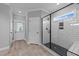Modern bathroom with glass-enclosed shower, white subway tile, neutral color palette and wood tile floors at 30 Devilwood Dr, Four Oaks, NC 27524