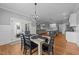 Open-concept dining room with hardwood floors, modern chandelier, open to the kitchen and living area at 30 Devilwood Dr, Four Oaks, NC 27524