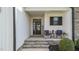 Inviting front porch with stone steps, seating, and a decorative sign, creating a welcoming entrance at 30 Devilwood Dr, Four Oaks, NC 27524