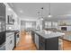 Modern kitchen with island, stainless steel appliances, granite countertops, and hardwood floors open to the living room at 30 Devilwood Dr, Four Oaks, NC 27524