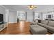Open-concept living room with hardwood floors, comfortable seating, and easy access to the foyer at 30 Devilwood Dr, Four Oaks, NC 27524
