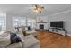 Cozy living room with a fireplace, plush sofa, and plenty of natural light from the large windows at 30 Devilwood Dr, Four Oaks, NC 27524