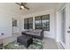 Relaxing covered patio featuring comfortable seating, ceiling fan, and pleasant natural light from the adjacent windows at 30 Devilwood Dr, Four Oaks, NC 27524