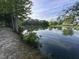 Beautiful view of pond surrounded by trees and foliage, reflecting the sky above at 30 Devilwood Dr, Four Oaks, NC 27524