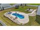 Aerial shot of a kidney-shaped in-ground pool surrounded by a concrete deck and landscaping, perfect for relaxation at 30 Devilwood Dr, Four Oaks, NC 27524