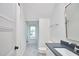 Well-lit bathroom with gray counters, tiled floor, and arched window with a view at 301 Georgetown Rd, Raleigh, NC 27608