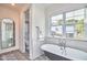 Elegant bathroom features a clawfoot tub, bright window and stylish shower at 301 Georgetown Rd, Raleigh, NC 27608