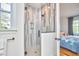 Bathroom with sleek glass shower and gray textured tile walls, adjacent to bedroom at 301 Georgetown Rd, Raleigh, NC 27608