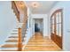 Bright foyer featuring hardwood floors, staircase with wooden steps, and decorative lighting, creating a welcoming space at 301 Georgetown Rd, Raleigh, NC 27608