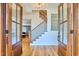Elegant foyer with wood floors, a staircase with wrought iron railings, and stylish light fixtures at 301 Georgetown Rd, Raleigh, NC 27608