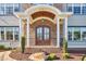 Inviting front porch with a brick archway, elegant double doors, and decorative shrubs, creating a welcoming entrance at 301 Georgetown Rd, Raleigh, NC 27608