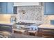 Gourmet kitchen featuring a range, mosaic backsplash, pot filler, and custom cabinetry at 301 Georgetown Rd, Raleigh, NC 27608