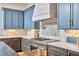 Gourmet kitchen featuring a range, mosaic backsplash, pot filler, and custom cabinetry at 301 Georgetown Rd, Raleigh, NC 27608