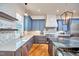 The spacious kitchen features stainless steel appliances, a marble backsplash, and an island with a marble countertop at 301 Georgetown Rd, Raleigh, NC 27608