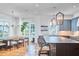 Open-concept kitchen and dining area features modern lighting, a large dining table, and a kitchen island with seating at 301 Georgetown Rd, Raleigh, NC 27608