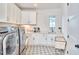 Well-lit laundry room with patterned tile floors, sink and modern washer and dryer set at 301 Georgetown Rd, Raleigh, NC 27608