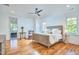 Bright main bedroom with hardwood floors, ceiling fan, and ensuite bathroom with a bathtub and shower at 301 Georgetown Rd, Raleigh, NC 27608