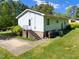 The backyard of the home featuring green grass, trees, the house, and a patio at 3016 Fields Dr, Raleigh, NC 27603