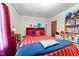 Bedroom with a red and blue bed, bookcase, and a window at 3016 Fields Dr, Raleigh, NC 27603